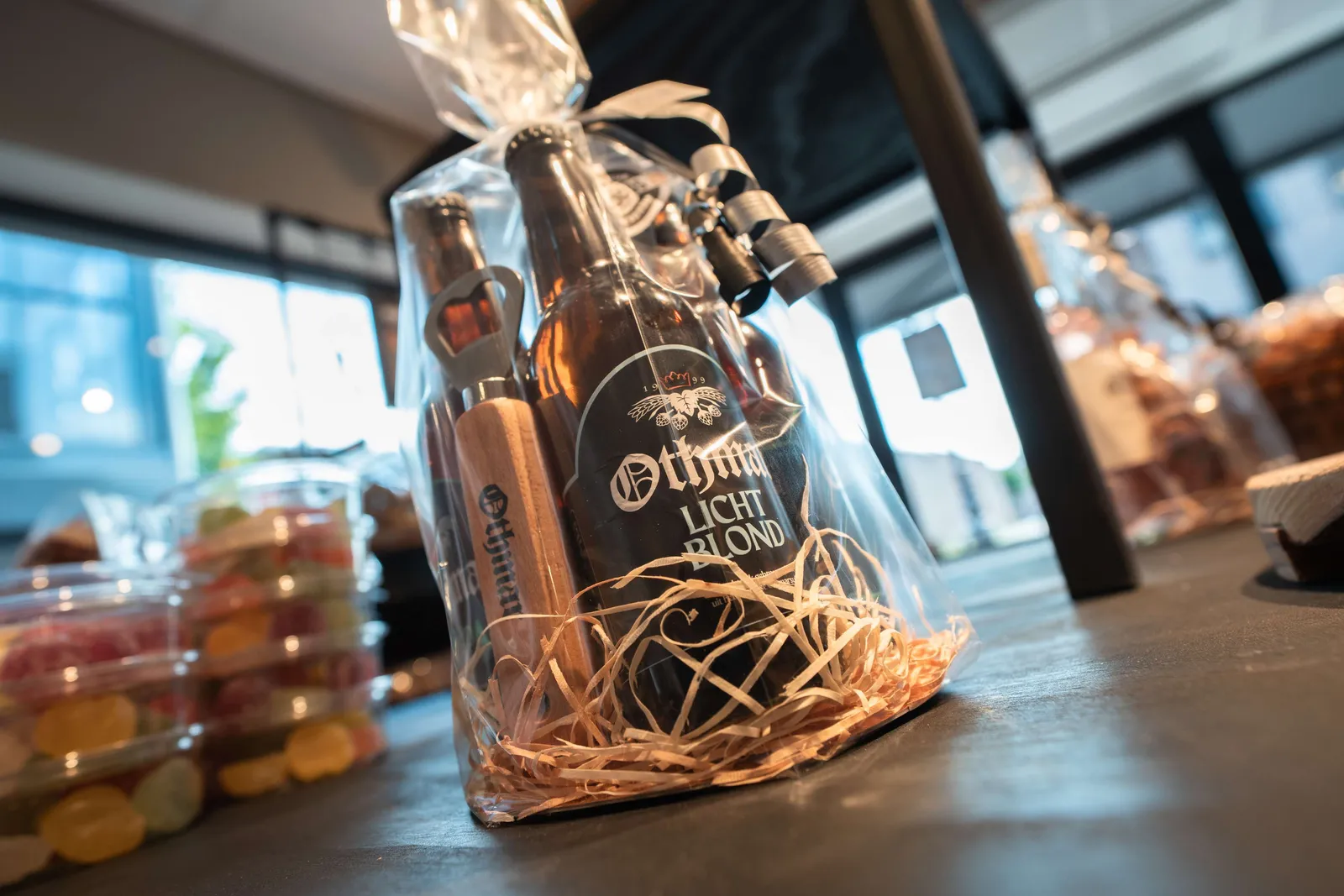 Ingepakt cadeaupakket met een flesje bier en een houten opener